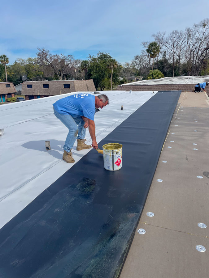 Wide view of a commercial roofing installation site with materials and tools laid out, demonstrating the scale of roofing projects.